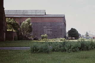 The photo shows probably the first artistic mural in Poland, made by Christian Wabl in 1973, during the Fifth Biennial of Spatial Forms in Elbląg. The mural showing a letter to the people made of flowers' pictographs instead of letters of the alphabet was painted on the wall of the Mechanical Works Zamech company. Photo by KwieKulik.