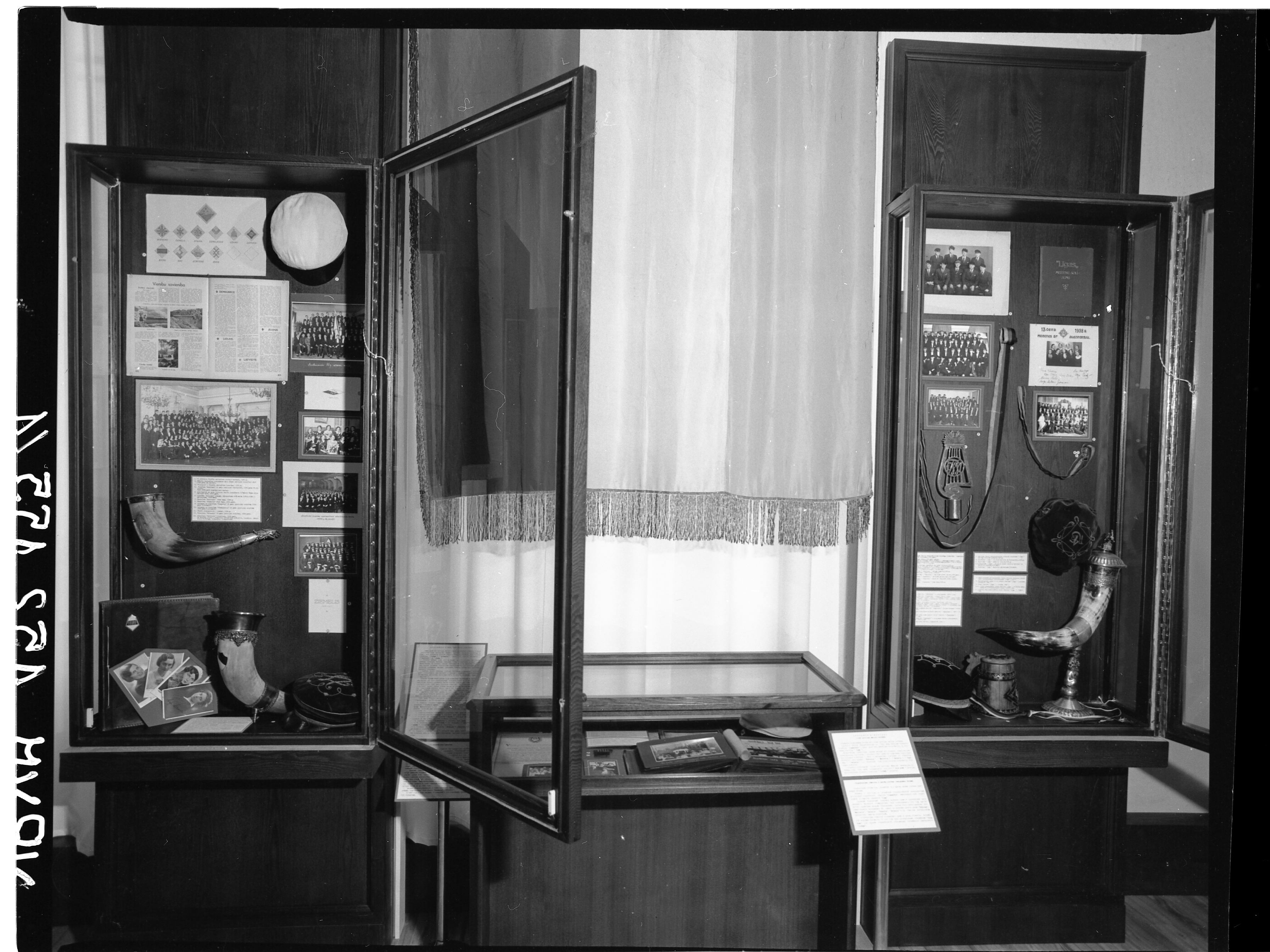 Photo from the exhibition 'Student organizations in Latvia'. On photo: materials about the Latvian University Academic Student-Women Union 'Ausma' (on the left side) and about Latvian Conservatory student organizations 'Līgusonis' (men) and 'Līga'(women) (on the right side). In the middle - a flag of the Latvian University Jewish Student Society 'Vetulia'.Author: Ilgvars Gradovskis, 1991. VRVM 152.155/1 