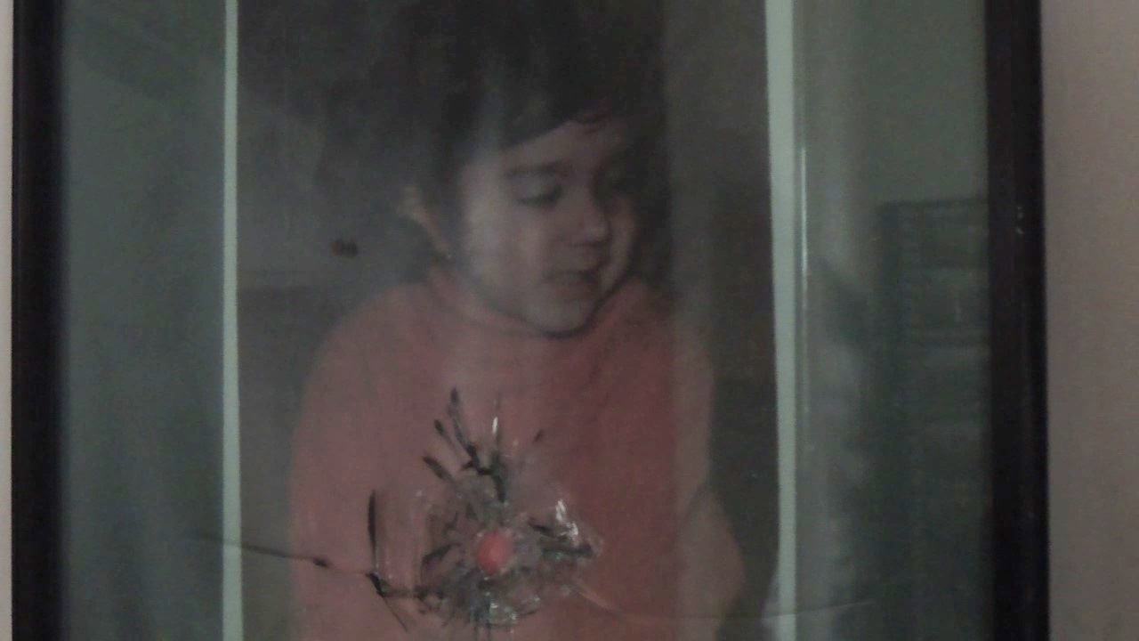 Picture of Cristina Lungu, the youngest victim of the revolution, behind a window glass with a bullet hole