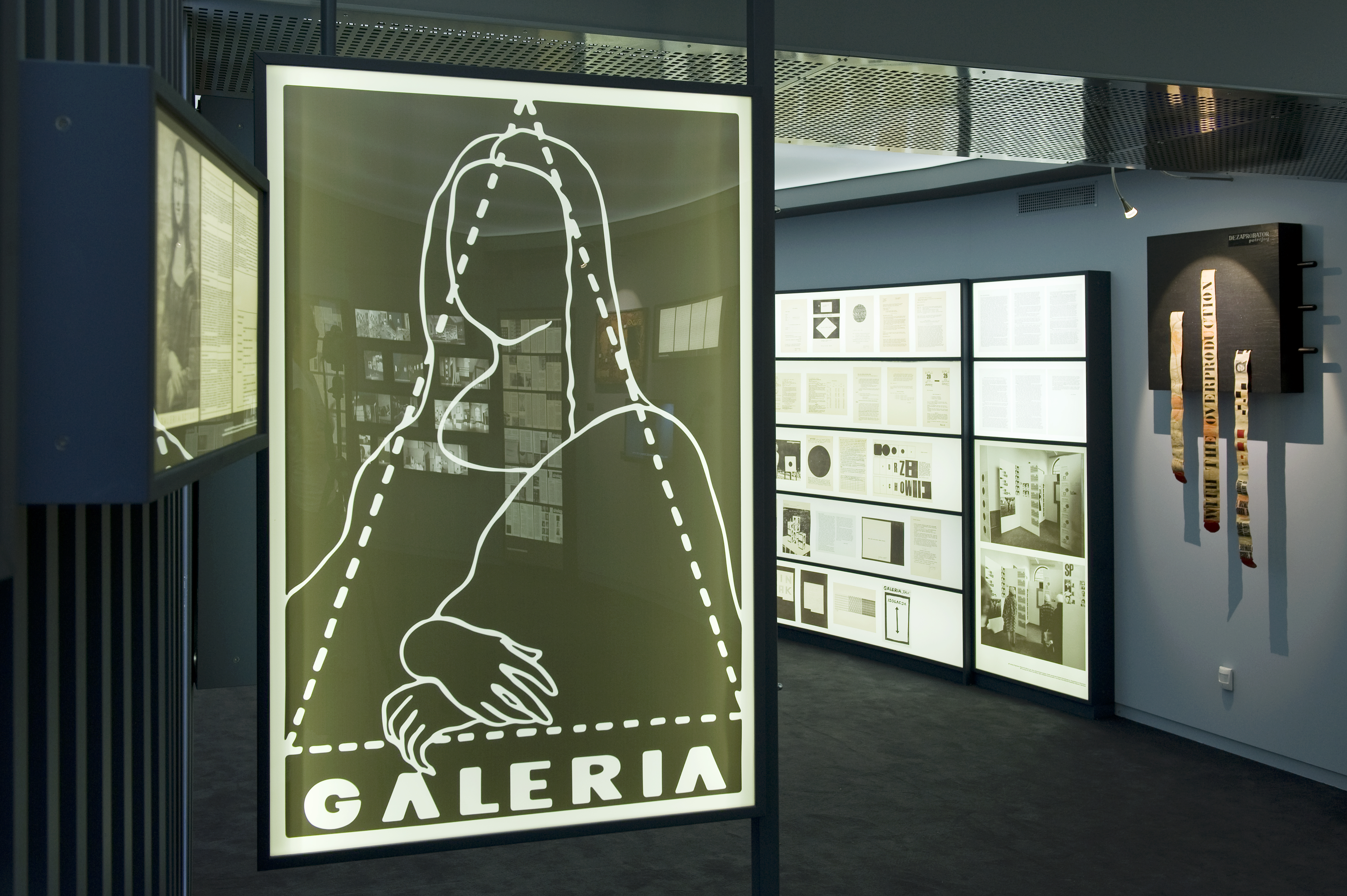 Widok wystawy stałej Wrocław „Archiwum Jerzego Ludwińskiego” w Muzeum Współczesnym Wrocław. Na pierwszym planie logotyp Galerii pod Moną Lisą projektu Zbigniewa Paluszaka, redaktora graficznego miesięcznika „Odra”, na podstawie rysunku Władysława Strzemińskiego z „Teorii widzenia” (1985), fot. Małgorzata Kujda, © DTZSP