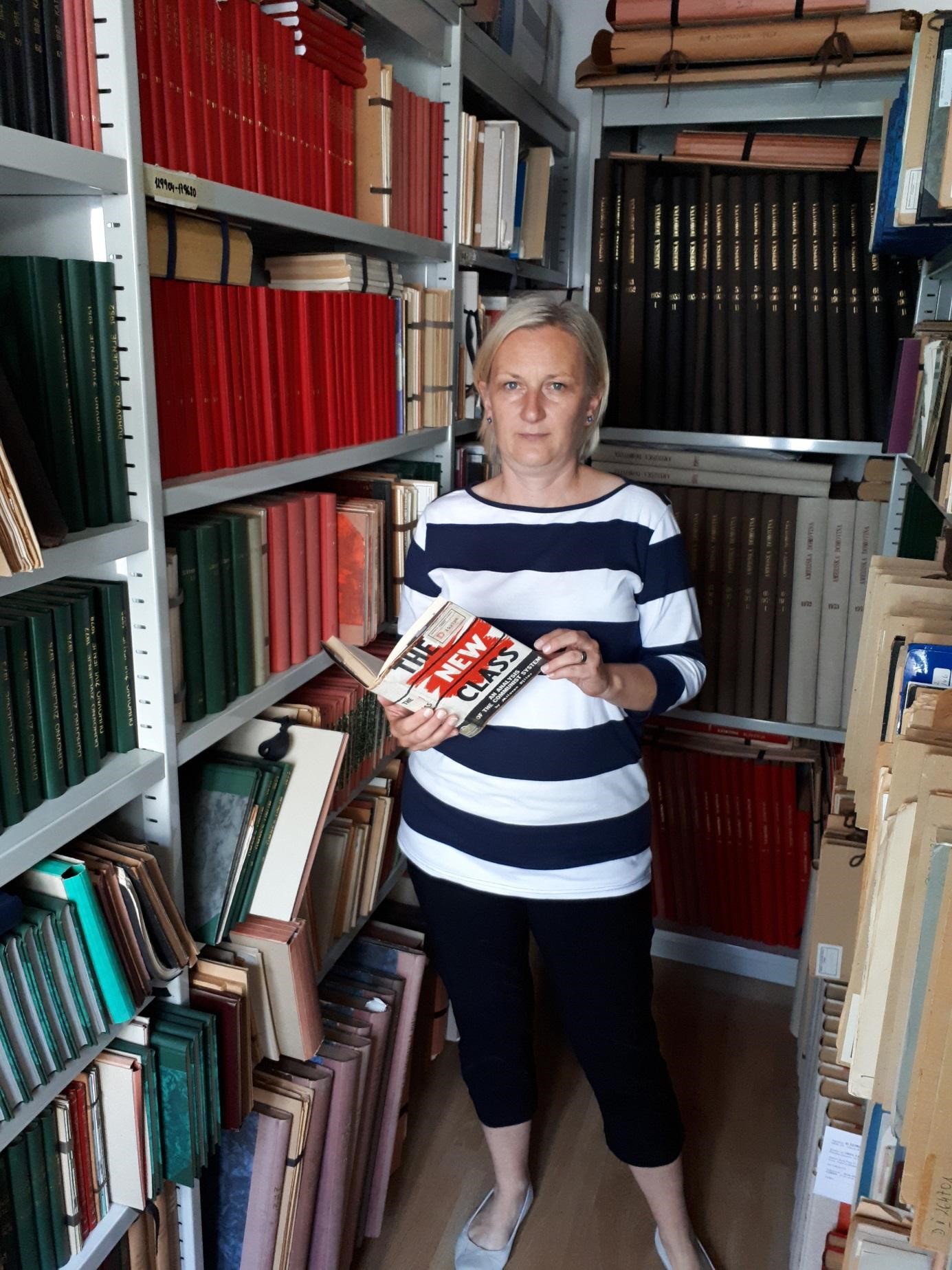 Helena Janežič in v ozadju D fond, ki se nahaja v sklopu Zbirke slovenskega tiska izven Republike Slovenije v Narodni in univerzitetni knjižnici v Ljubljani (2018-05-24). 