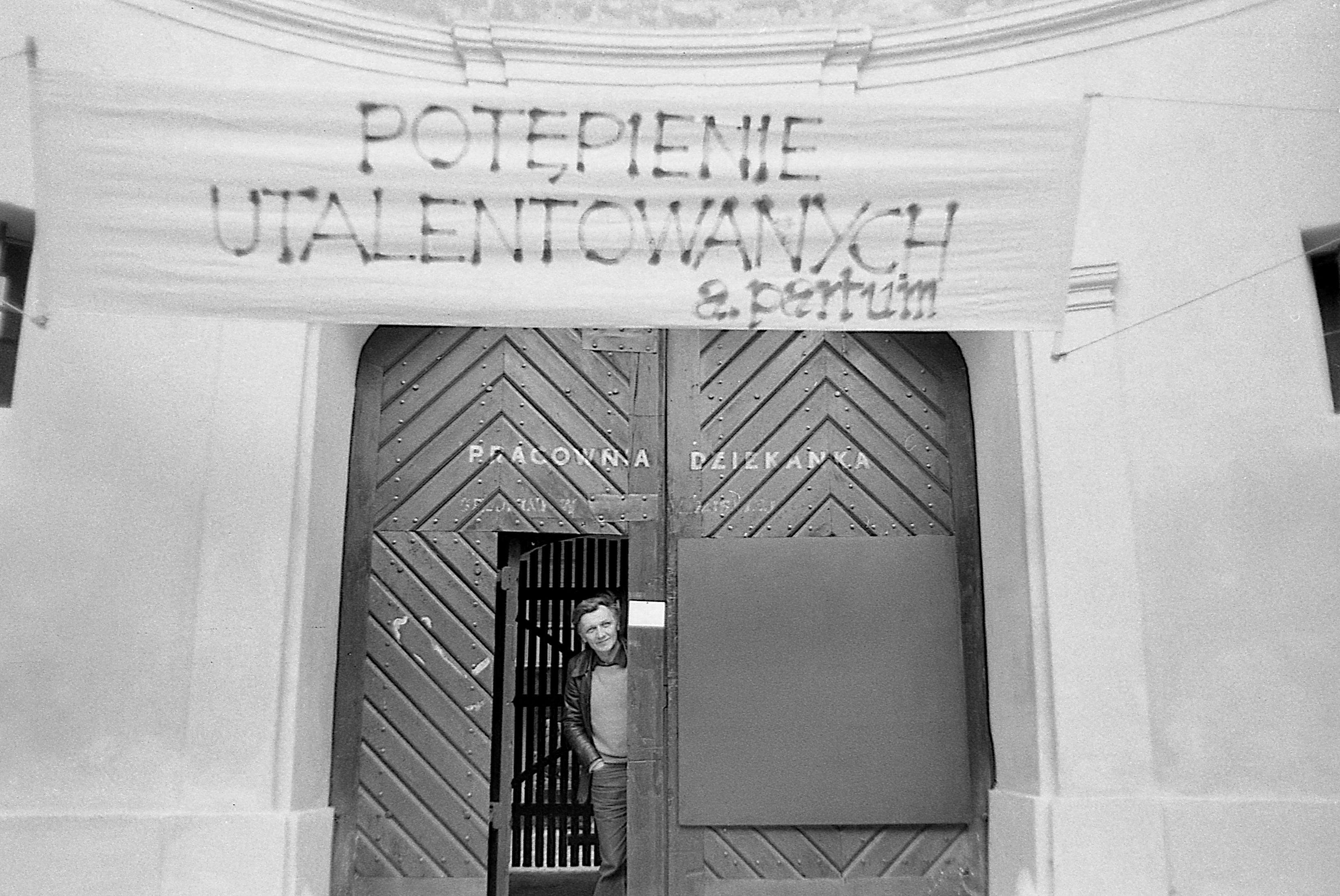 Andrzej Partum looking from the doors of the Dziekanka Workshop with his banner 'Potępienie utalentowanych' (Damnation of the talented), October 8, 1984. Photo by Jerzy Onuch.